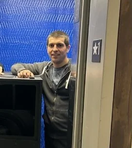 Riley Irving standing next to a speaker cabinet